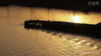 金色夕阳下货轮船河流逆光剪影